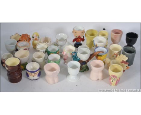 A collection of novelty egg cups to include cups by Goebel, Weiss Royal Doulton Bunnykins etc please see images
