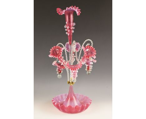 A cranberry glass epergne of typical form, with central trumpet over three lower trumpets, and three canes supporting hanging