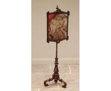 An early Victorian walnut pole screen, the needlework panel glazed within a carved swept frame, upon an acanthus baluster upr