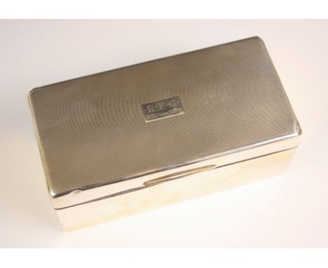 A George V silver mounted cigarette box, William Neale and Son, Birmingham 1927, the hinged cover with engine turned decorati