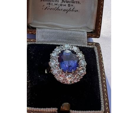 A mid 20th century certified colour change sapphire cluster, the oval cut sapphire (stated as 4.62 carats) within a border of