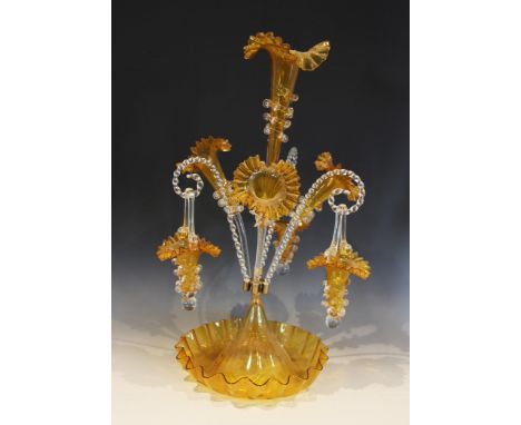 A yellow glass epergne of typical form, with central trumpet over three lower trumpets, and three canes supporting hanging ba