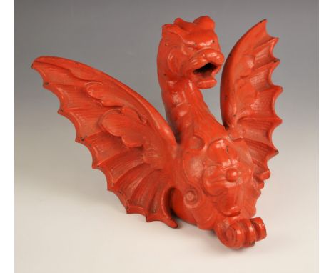 A cast iron red painted decorative bracket modelled as a winged dragon, 30cm wide 