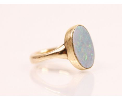 An 'opal' ring, the oval shaped opal set within a rub over yellow metal mount and plain polished band, ring size H, 5gms (unt