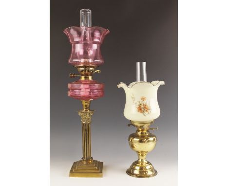 A Victorian cranberry glass oil lamp, mid 19th century, the reeded brass column with Corinthian capital set to a stepped plin