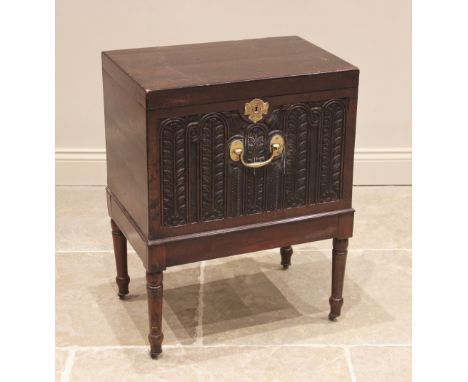 A George III mahogany cellarette, of rectangular hinged form, the front panel carved with lunette flowerheads and foliate vin