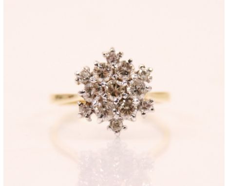 A 20th century diamond cluster ring, the ring designed as a snowflake with thirteen round cut diamonds within a claw set whit