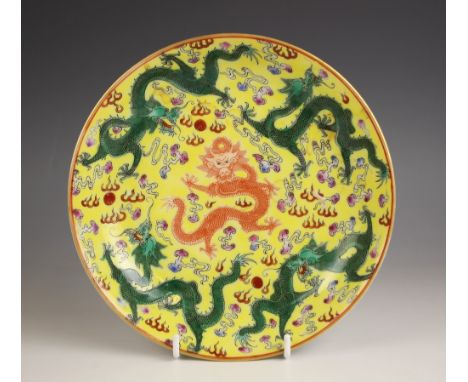 A Chinese porcelain yellow ground dragon dish, Qianlong seal mark, the shallow circular dish centrally decorated with an iron