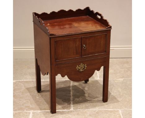 A George III mahogany tray top night table, the shaped three quarter gallery above a pair of cupboard doors and a sliding com