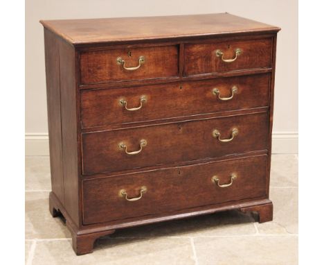 A George III oak chest of drawers, the rectangular moulded top over two short and three long graduated and cock beaded drawer