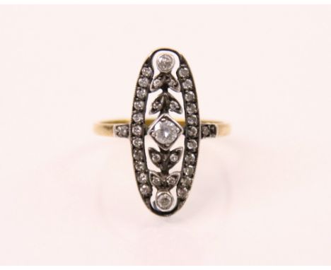 An Edwardian style diamond ring, the central round cut diamond with diamond set leaf and white metal openwork lozenge shaped 