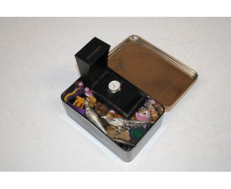 An advertising tin and contents to include various enamel decorated badges, cloth badges, coinage, vintage whistle, wrist wat
