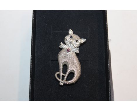 A vintage Sterling silver cat brooch with ruby set collar and emerald eyes 