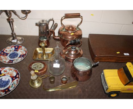 A quantity of various brass and copper items including kettles, chamber stick, saucepan etc.; and a glass claret jug (no stop