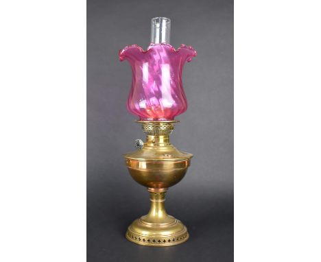 An Early 20th Century Brass Oil Lamp with Cranberry Glass Shade and Plain Glass Chimney, 57cms High 