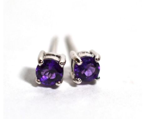A pair of 18 carat white gold amethyst stud earrings, a round  cut amethyst in a claw setting, measure 3.9mm in diameter, wit