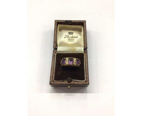 9ct gold amethyst three stone ring interspaced with diamonds, size M½Weight 4.6 grams