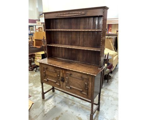 1920's/30's oak two height dresser with open shelves above two geometric panelled doors below on bobbin turned and block legs