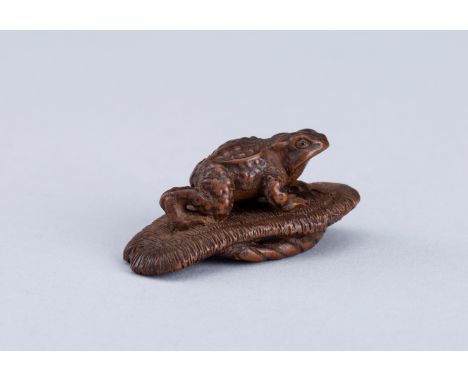 A WOOD NETSUKE OF A TOAD ON SANDAL, EDO PERIODJapan, 19th century, Edo period (1615-1868)Well-carved as a toad perched on an 
