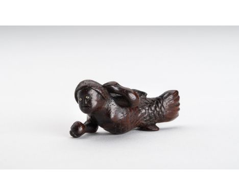 A WOOD NETSUKE OF A SWIMMING NINGYO (MERMAID)Japan, Meiji period (1868-1912)The ningyo is half fishlike, apart from the arms,
