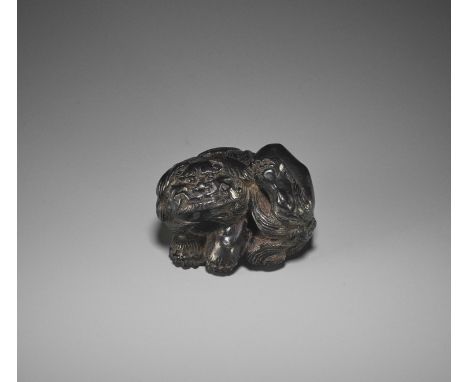 KOKEI: A RARE EBONY WOOD NETSUKE OF A SHISHI SCRATCHING HIS EARBy Kokei, signed Kokei Japan, Tsu, 19th century, Edo period (1