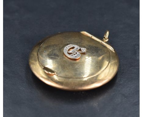 A 9ct gold and diamond chip set powder compact, of circular form the hinged cover with diamond chip set applied initial G, th