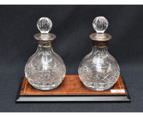 A pair of Queen Elizabeth II silver-mounted cut-crystal decanters, the globular bodies with cut with a band of repeating deco