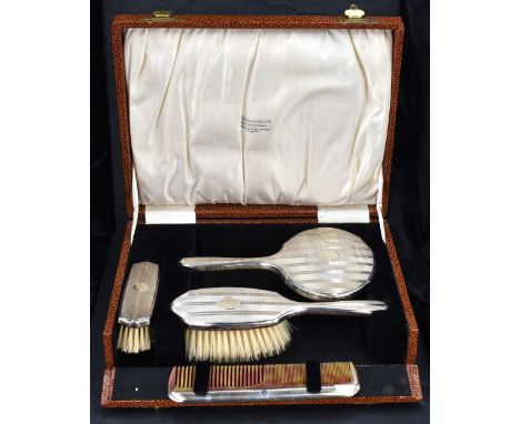 A George V silver mounted travelling dressing/brush set, comprising hand mirror, comb, clothes and hair brush, each with band