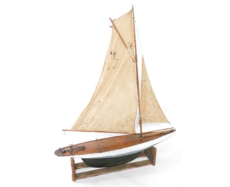 A wooden scale model of a single masted yacht, fully rigged, on a stand, 138cm wide.