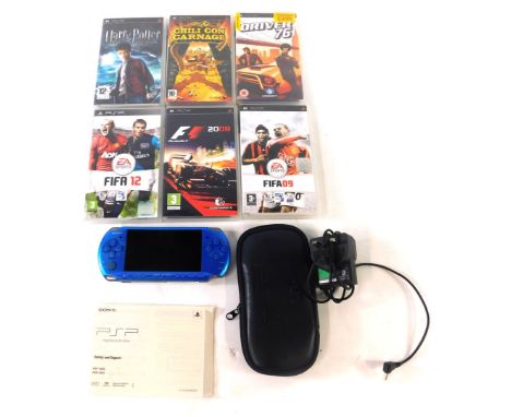 A Playstation PSP console in blue, with carrying case, power cable and six games comprising of Chilli Con Carnage, F! 2009, F