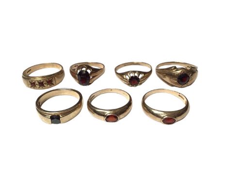 Seven 9ct gold rings to include six single stone garnet rings and a three stone ringTotal weight 26.3 gramsOne ring is unmark