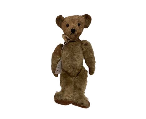 Early 20th century small bear with boot button eyes, wood wool stuffing, disc joints, mohair plush, vertically stitched nose.