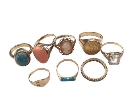 Five 9ct gold rings including a cameo and coin ring, yellow metal pink coral ring, yellow metal eternity ring and a turquoise
