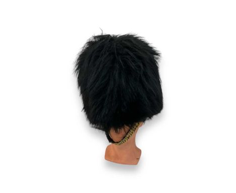 20th century bear skin hat / helmet with canework interior and brass chin chains, on a mannequin head.