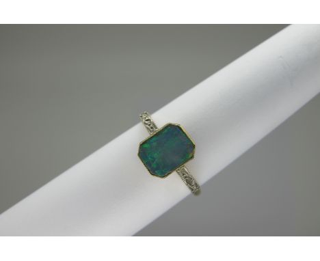 An Opal (Doublet) and Diamond Set Ring, rectangular collet rubover set (stone cracked), between diamond chip inset shoulders,