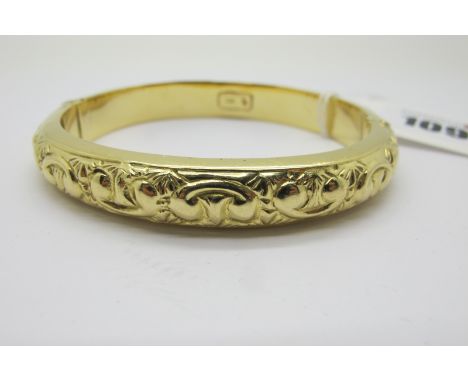 A Modern Bangle, allover detailed in relief, hinged to snap clasp, stamped "750" (internal diameter 6cm) (30grams). 