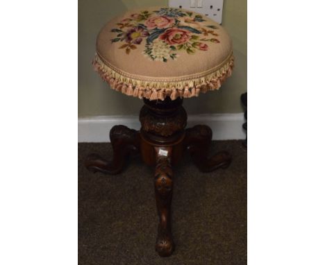 Victorian carved walnut revolving piano stool, standing on a turned pillar and tripod base   Condition: 