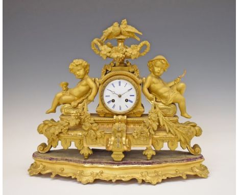 19th Century French gilt spelter figural cased mantel clock, surmounted with an urn with two birds and flowers, flanked by a 