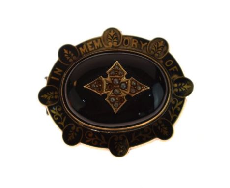Victorian gilt metal oval target design mourning brooch, the black enamel border with the script 'In Memory Of' with glass pa