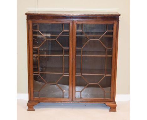 Early 20th Century mahogany cabinet bookcase fitted four shelves enclosed by a pair of astragal glazed doors and standing on 