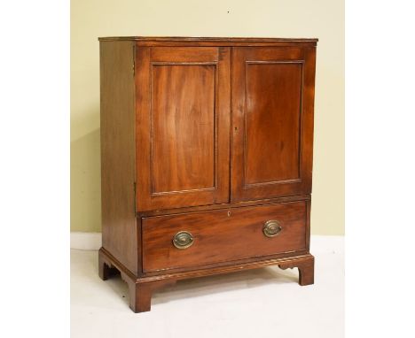 Mahogany two door cupboard having a fall flap below and standing on bracket feet   Condition: 