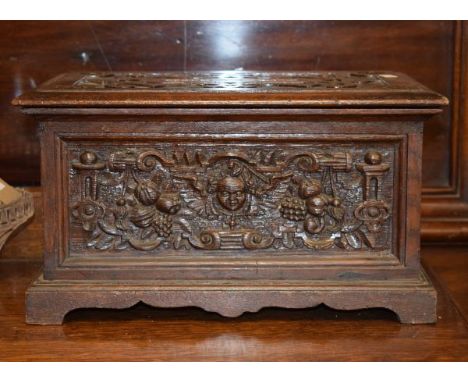 Late 19th/early 20th Century heavily carved oak correspondence box having a classical mask head and fruit decoration and stan