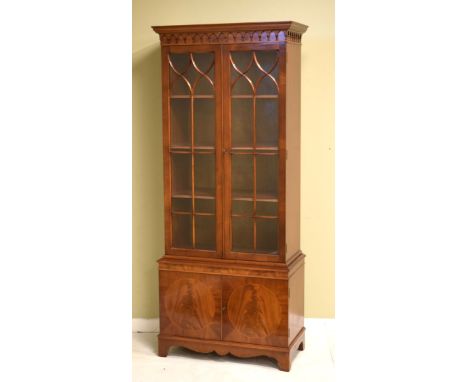 Reproduction mahogany cabinet bookcase, the upper section fitted four shelves enclosed by a pair of glazed doors, the base fi