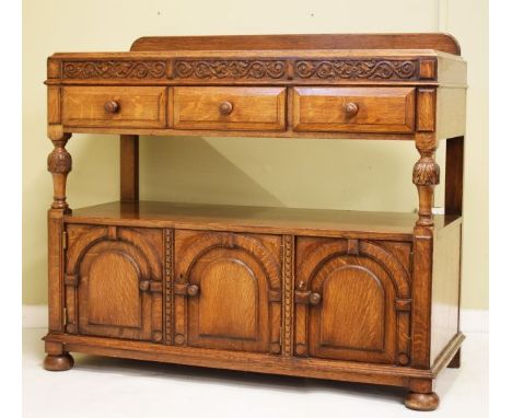 1930's period carved oak two tier buffet, having a carved frieze, two drawers below, the lower section fitted platform suppor