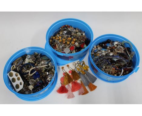 Three tubs containing a quantity of vintage and later costume jewellery and some fashion wristwatches etc. (3 tubs) 