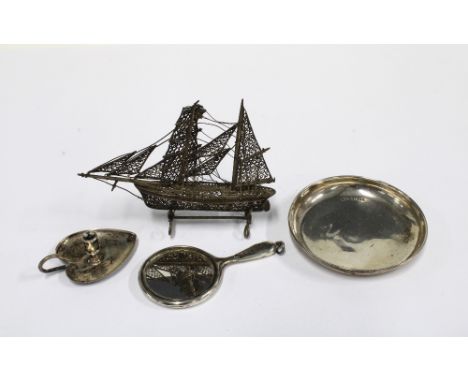 A small Birmingham silver pin dish, miniature white metal hand mirror, chamber candlestick and filigree boat, (4)