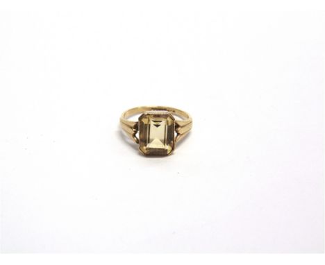 A 9CT GOLD AND CITRINE SINGLE STONE RING  the emerald-cut stone rub-over set between split leaf shoulders, Birmingham 1973, s