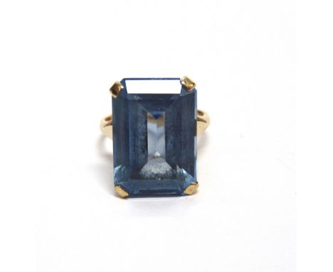 A 9CT GOLD AND BLUE SYNTHETIC SPINEL RING  the rectangular step cut stone claw set on a 'D' section shank with sizing beads, 