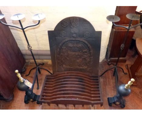 Cast iron dog grate with brass finials and a pair of tall cast candlesticks. Condition report: see terms and conditions