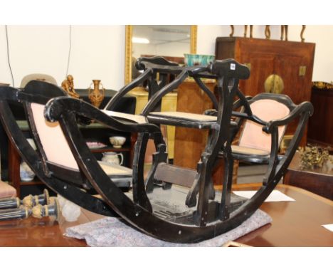 A VINTAGE CHILD'S ROCKING CHAIR FOR TWO PLUS ONE, EBONIZED FRAME